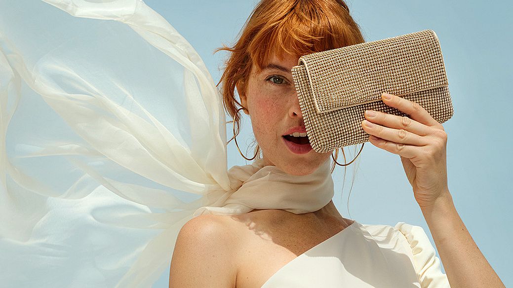 Una donna si copre il viso con una borsa, nascondendone la metà sinistra. L'immagine è utilizzata come immagine di intestazione per la pagina VIP Club e contiene anche i