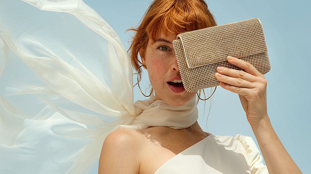 Una donna si copre il viso con una borsa, nascondendone la metà sinistra. L'immagine è utilizzata come immagine di intestazione per la pagina VIP Club e contiene anche i