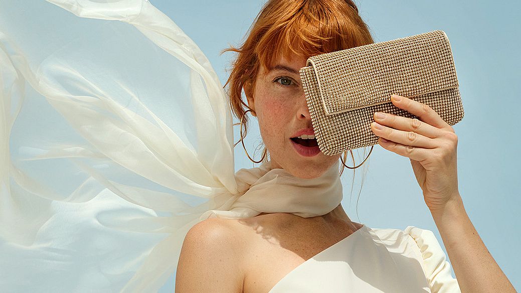 Una donna si copre il viso con una borsa, nascondendone la metà sinistra. L'immagine è utilizzata come immagine di intestazione per la pagina VIP Club e contiene anche i