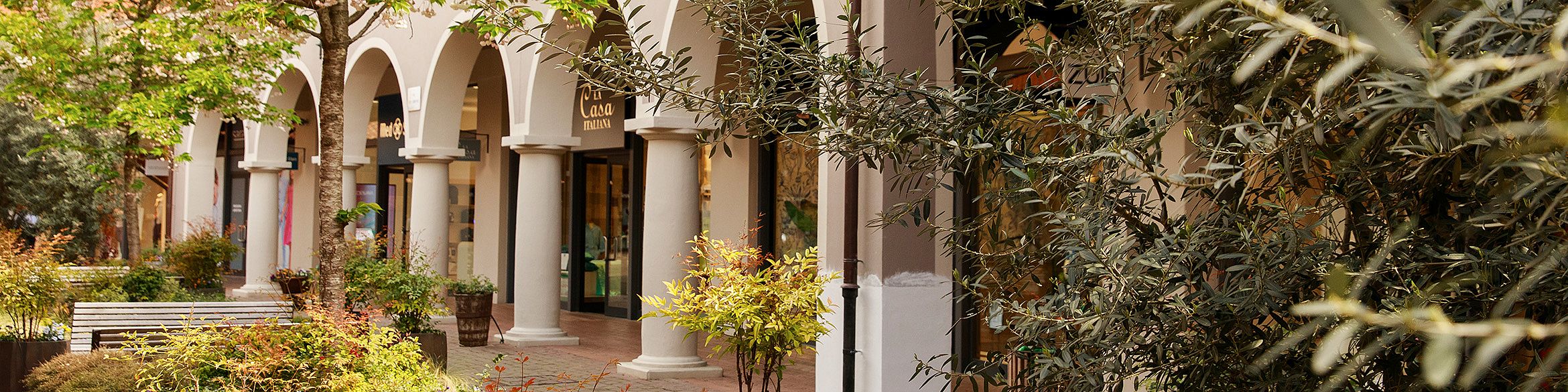 L'immagine mostra gli archi degli ingressi dei negozi del centro commerciale. Viene utilizzata come immagine di intestazione per la sezione “Chi siamo”.